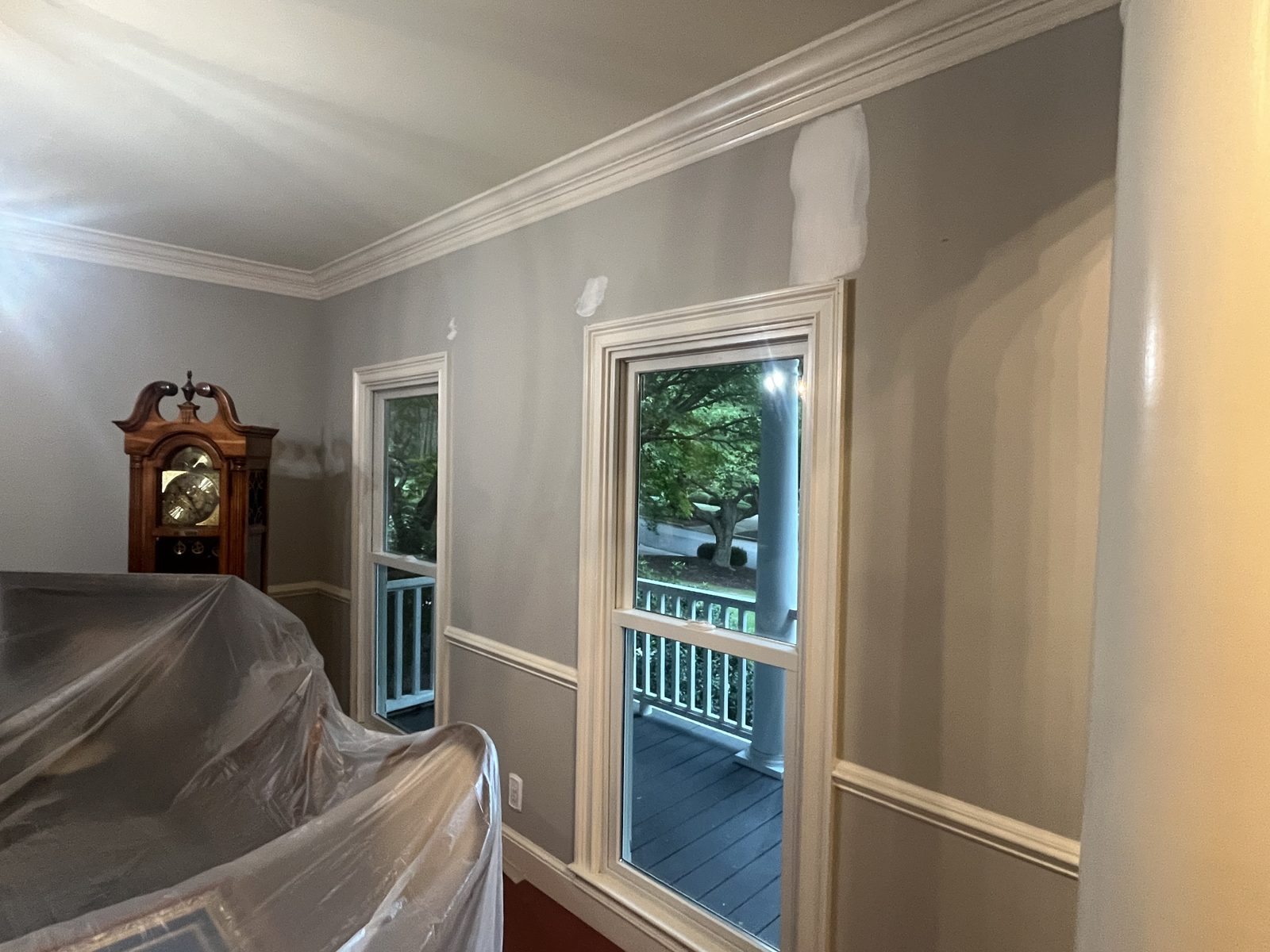 Dining room corner with furniture covered and walls patched for painting