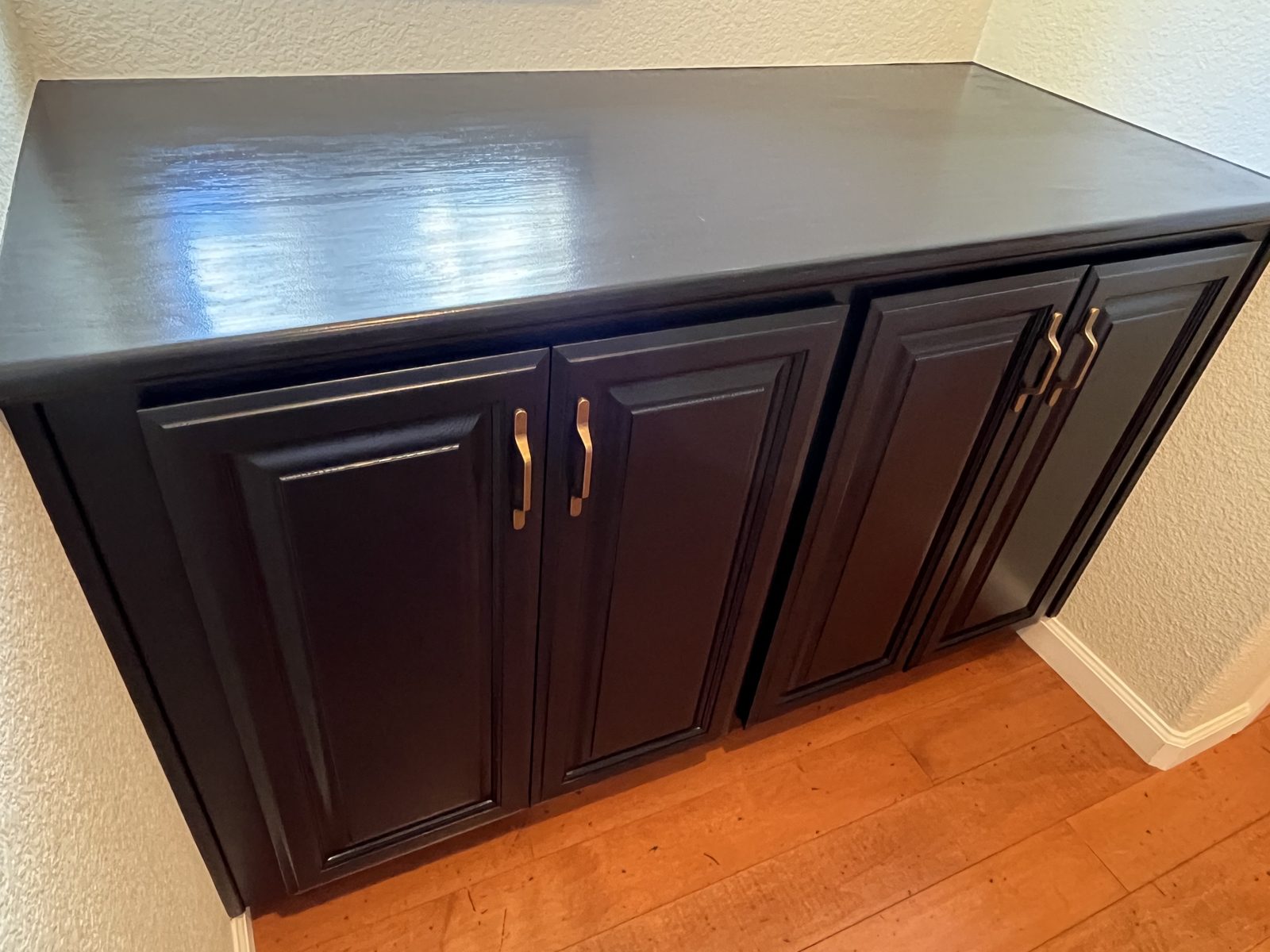 The same hall cabinet finished in a dark glossy paint with pulls on the doors